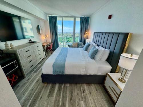 a hotel room with a bed and a large window at Balcony Ocean View ! Pool - WiFi - Gym - Parking in Miami
