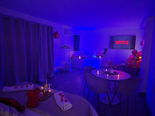 a purple room with two tables and balloons in it at Love Room - Cocon Room - Toulon - Ollioules in Ollioules