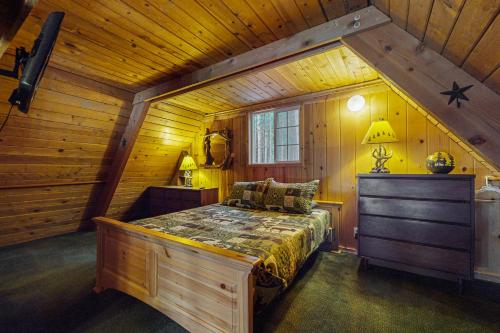 a bedroom with a bed in a wooden cabin at The Hideaway in Ronald