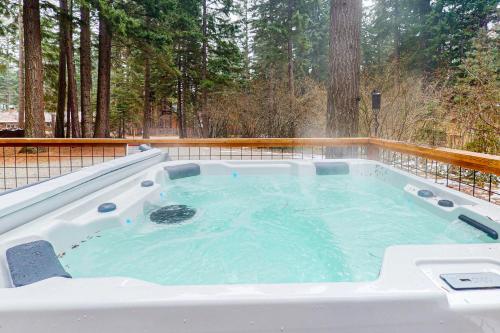 a hot tub on a deck with trees in the background at The Hideaway in Ronald