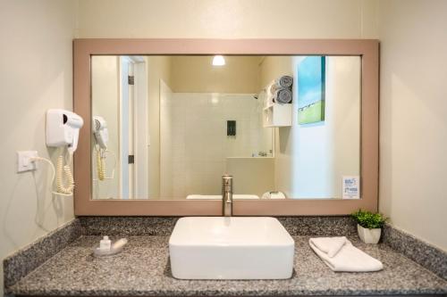 ein Badezimmer mit Waschbecken und Spiegel in der Unterkunft Boca Olas Resort Villas in La Libertad