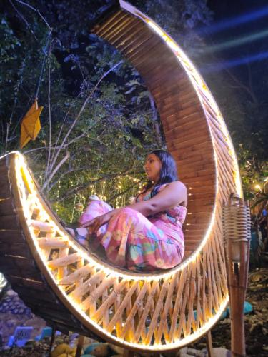 a woman is sitting in a wicker chair at River Glamping Melgar in Melgar