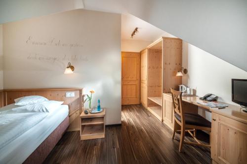 1 dormitorio con 1 cama y escritorio con ordenador en Hotel Eschenhof en Kirchheim