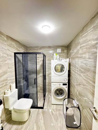 a bathroom with a toilet and a washing machine at BISI penthouse in Skopje