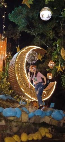 a person is standing on a chair with an umbrella at River Glamping Melgar in Melgar