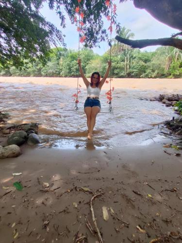a girl on a swing on the beach at River Glamping Melgar in Melgar