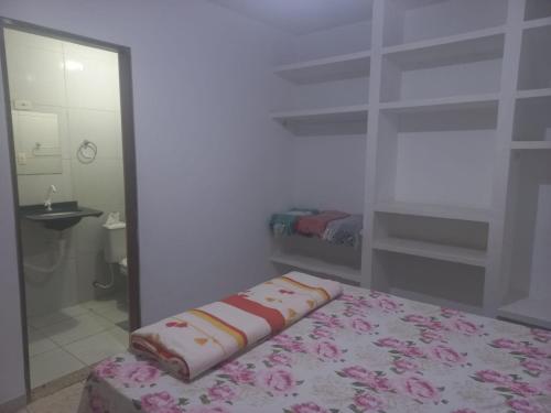 a room with a bed and a bathroom with a mirror at Apartamento para temporada Garanhuns in Garanhuns