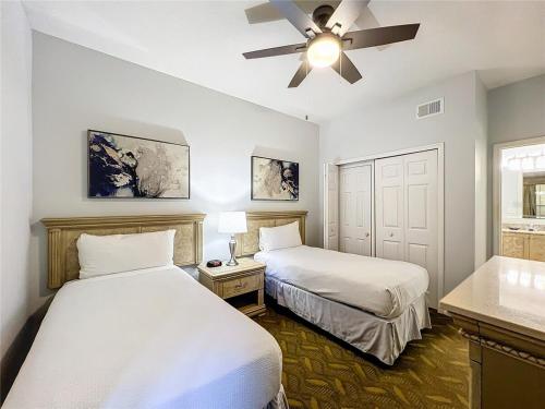 a bedroom with two beds and a ceiling fan at Spacious 3 Bed 3 Bath Luxury Condo 5 min from Disney in Orlando
