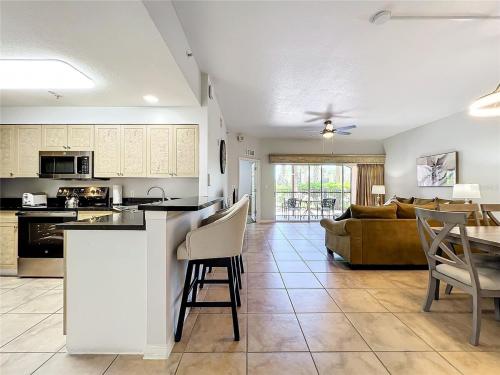 a kitchen and living room with a couch and a table at Spacious 3 Bed 3 Bath Luxury Condo 5 min from Disney in Orlando