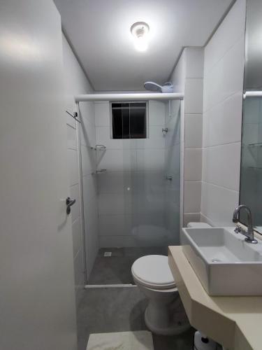 een badkamer met een douche, een toilet en een wastafel bij Apartamento aconchegante in Balneário Camboriú