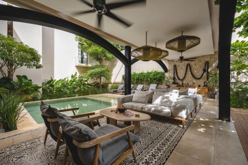 a living room with a couch and a pool at Adoro Hotel Boutique in Mérida