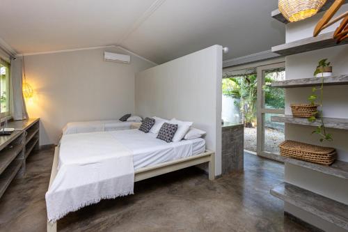 a bedroom with a bed and a large window at Casa Kokoro in Pipa