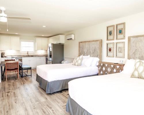 a bedroom with two beds and a kitchen with a table at 304 Queen Suite, 3rd Floor Nest in Surf City