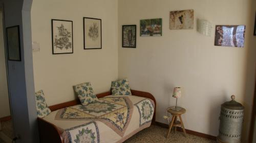 ein Schlafzimmer mit einem Bett und einem Stuhl sowie Bildern an der Wand in der Unterkunft Polcanto i Castagni appartamento in casa colonica in Borgo San Lorenzo