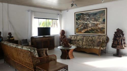 ein Wohnzimmer mit Sofa und Tisch in der Unterkunft Casa de praia Enseada in Guarujá