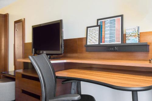 a computer desk with a monitor and a chair at Fairfield Inn & Suites by Marriott Santa Fe in Santa Fe