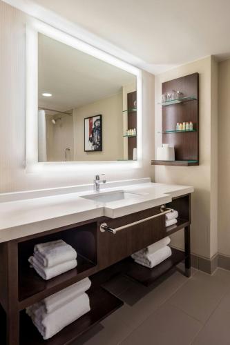 a bathroom with a sink and a large mirror at Delta Hotels by Marriott Philadelphia Airport in Philadelphia