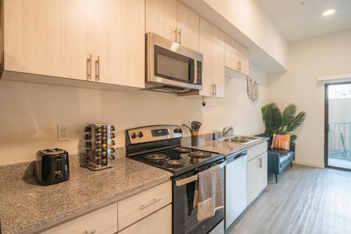 una cocina con estufa y microondas en Sunshine & Serenity! Large Pool and Fitness Center, en Phoenix