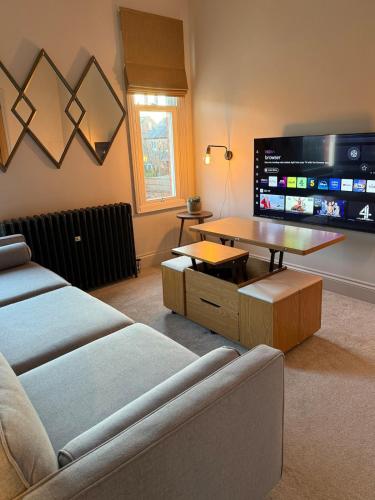 a living room with a couch and a flat screen tv at West Bridgford 2 Bed 2 Bathroom Apartment with parking in West Bridgford