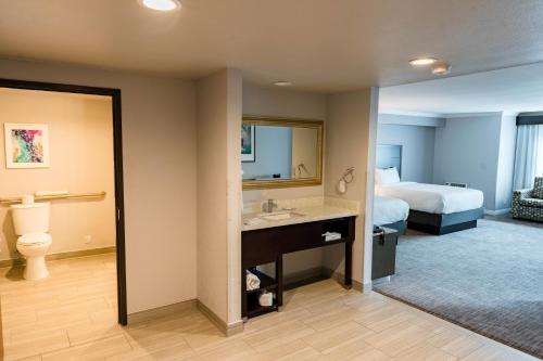 a hotel room with a bed and a bathroom at Amanzi Hotel, an Ascend Collection Hotel in Ventura