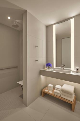 a bathroom with a sink and a mirror and towels at The Times Square EDITION New York in New York