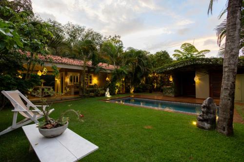 a backyard with a pool and a house at Casa Kokoro in Pipa