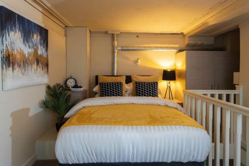 ein Schlafzimmer mit einem großen Bett mit einer gelben Decke in der Unterkunft Leeds Central Majestic - Rose Platinum Properties in Leeds