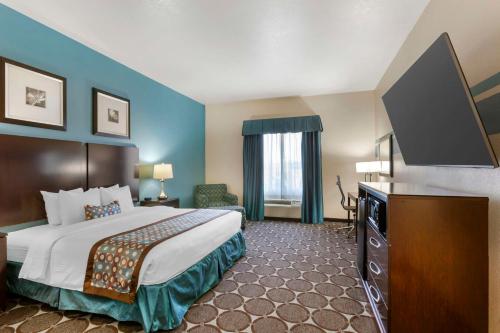 a hotel room with a bed and a flat screen tv at Best Western Sonora Inn & Suites in Nogales