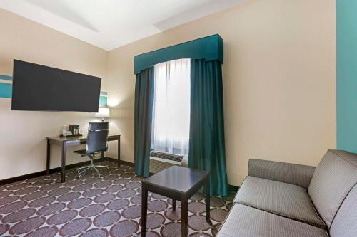 a living room with a couch and a desk and a window at Best Western Sonora Inn & Suites in Nogales