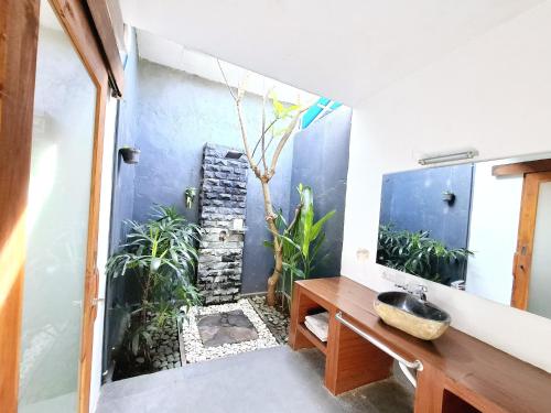 a bathroom with a sink and a shower with plants at Villa Manayasa in Lovina