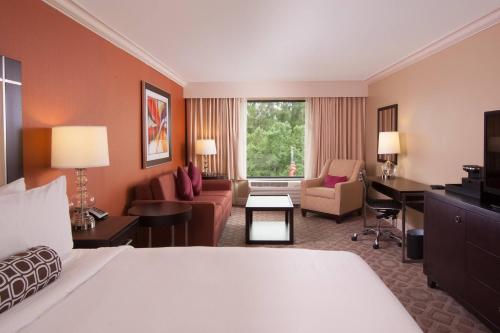 a hotel room with a bed and a living room at Delta Hotels by Marriott Orlando Lake Buena Vista in Orlando