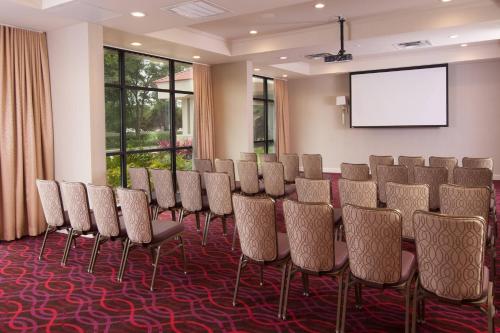 a conference room with a table and chairs and a screen at Delta Hotels by Marriott Orlando Lake Buena Vista in Orlando