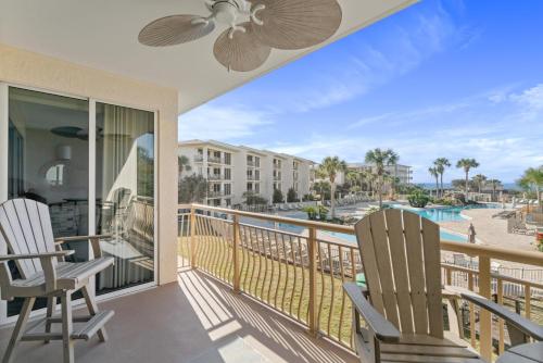 a balcony with two chairs and a view of the pool at High Pointe Resort 224 in Rosemary Beach