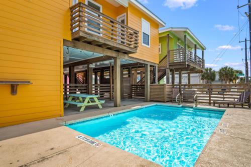 a house with a swimming pool in front of a house at Tequila Sunrise in Port Aransas