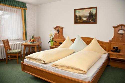 a bedroom with two beds and a table at Waldhotel Rennsteighof in Bad Liebenstein