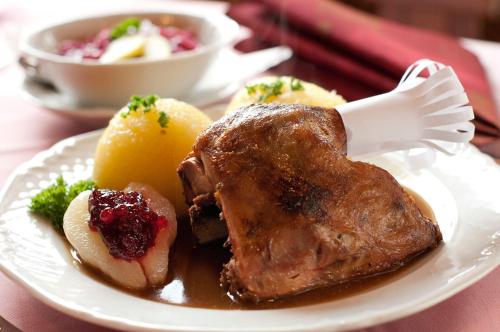 a plate of food with a piece of meat and potatoes at Waldhotel Rennsteighof in Bad Liebenstein