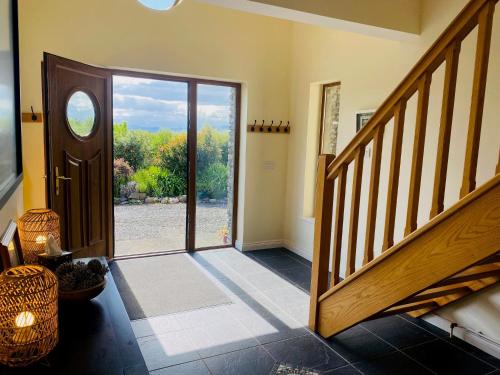 a hallway with a staircase and a sliding glass door at 3 bedroom home 15 mins drive from Kenmare town in Ardea Bridge