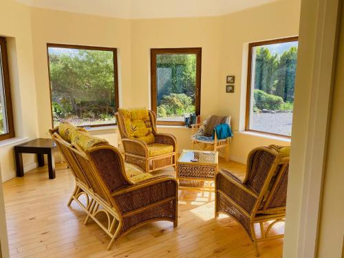 a living room with rocking chairs and windows at 3 bedroom home 15 mins drive from Kenmare town in Ardea Bridge