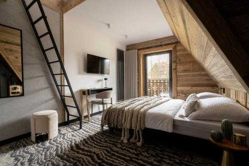 a bedroom with a large bed and a staircase at Kama Lama in Zakopane