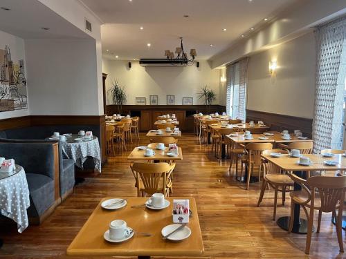 una sala da pranzo con tavoli e sedie in legno di Hotel Marbella a Buenos Aires