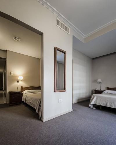 a large bedroom with two beds and a mirror at Hotel Marbella in Buenos Aires
