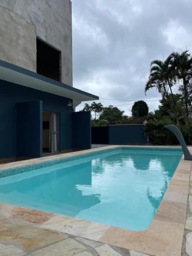 a swimming pool in front of a house at Flat Beija-Flor - 500m da praia in Ubatuba
