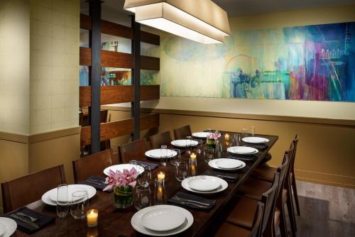 a dining room with a long table with plates and candles at Hotel Spero, Vignette Collection by IHG in San Francisco