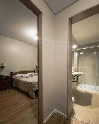 a bedroom with a bed and a bathroom with a mirror at Hotel Marbella in Buenos Aires