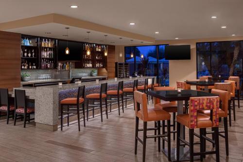 a restaurant with tables and chairs and a bar at Delta Hotels by Marriott Anaheim Garden Grove in Anaheim