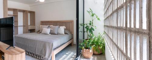 a bedroom with a bed and a balcony with plants at Casa Teresa by Barrio México in Guadalajara