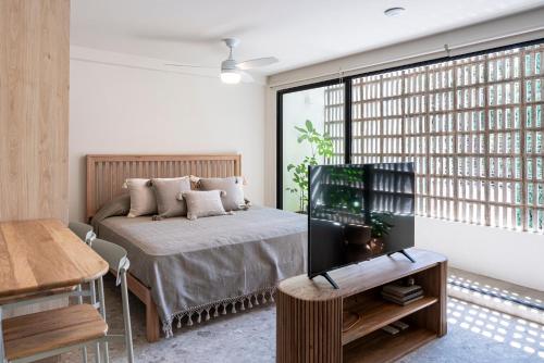 グアダラハラにあるCasa Teresa by Barrio Méxicoのベッドと大きな窓のある寝室
