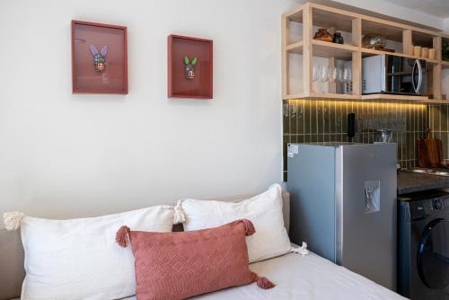 a kitchen with a refrigerator and a couch with pillows at Casa Teresa by Barrio México in Guadalajara