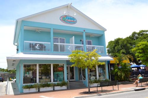 a woman sitting on a bench in front of a blue building at One Ocean - A 1101 in Sarasota