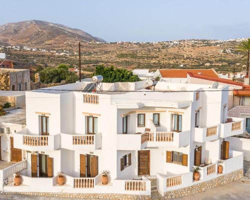 a white apartment building with balconies on a hill at Theoxenia Kasos Luxury Apartments in Panayía
